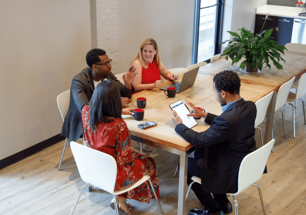 Group of professionals setting at a meeting table having a conversation.