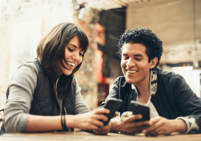 Two people smiling and looking at a phone